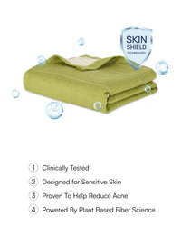 Folded green towel with 'Skin Shield Technology' badge and product features listed on a white background