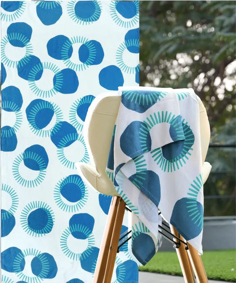 Blue and white patterned towel draped over a chair with a matching fabric background.