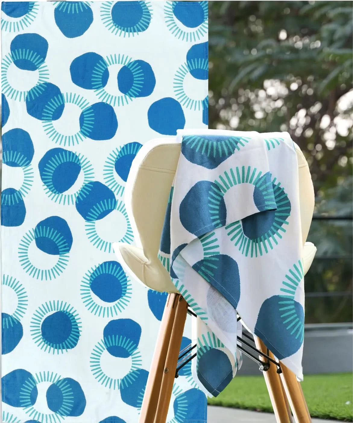 Blue and white patterned towel draped over a chair with a matching fabric background.