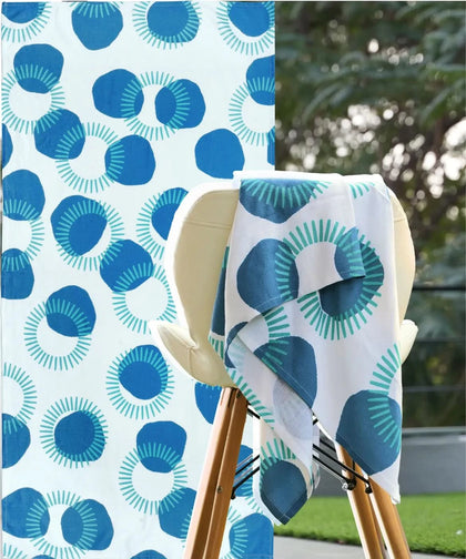 Blue and white patterned towel draped over a chair with a matching fabric background.
