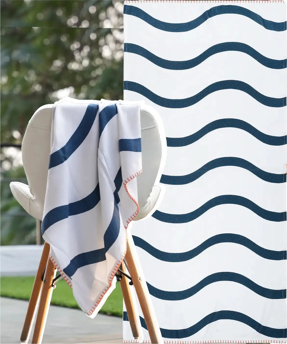 Navy and white striped towel draped over a chair with a blurred outdoor background