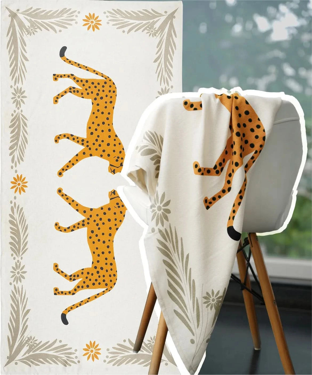Blanket with cheetah design draped over a chair, with a decorative wall in the background