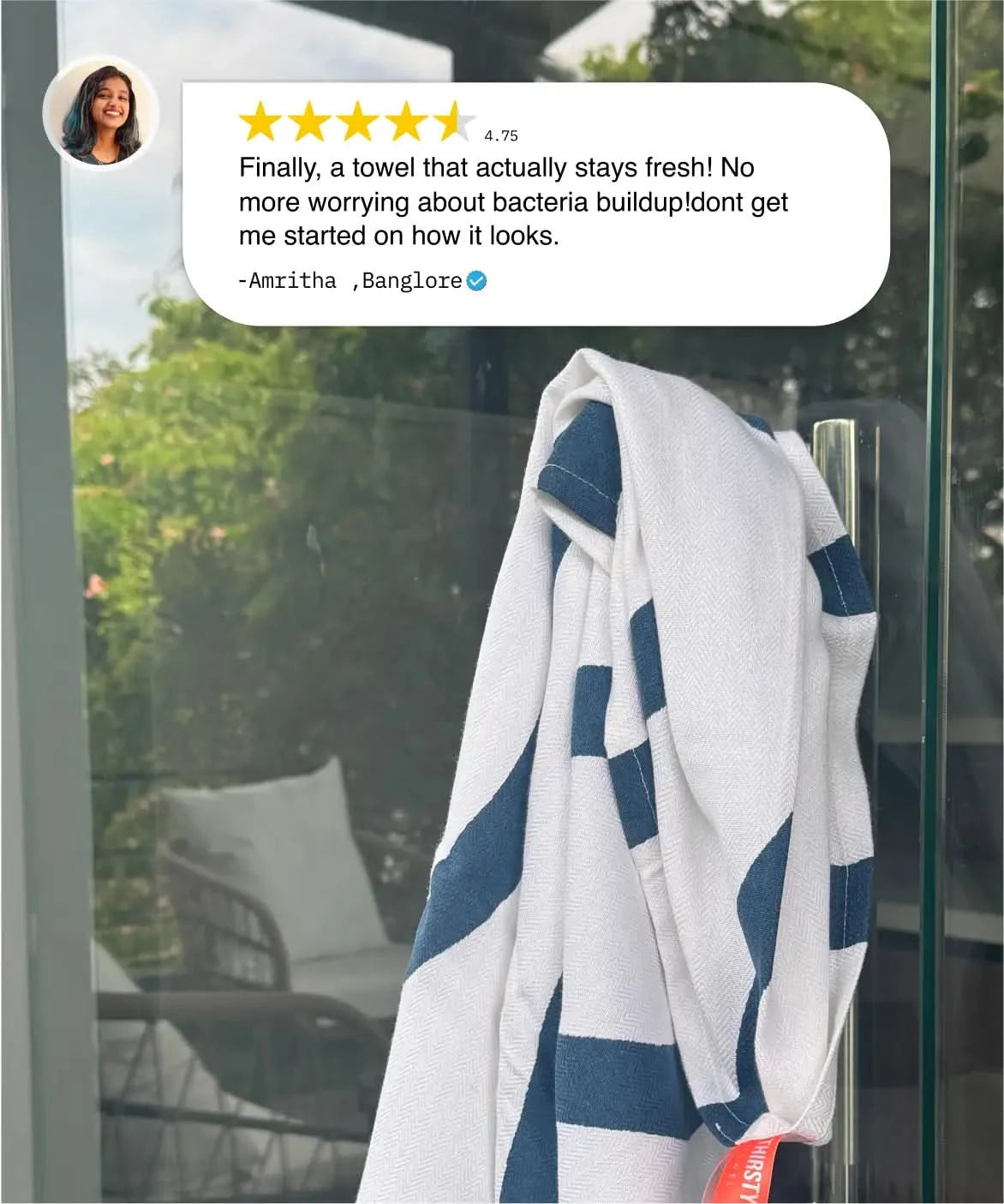 Blue and white striped towel hanging on a glass door with a five-star review above it.