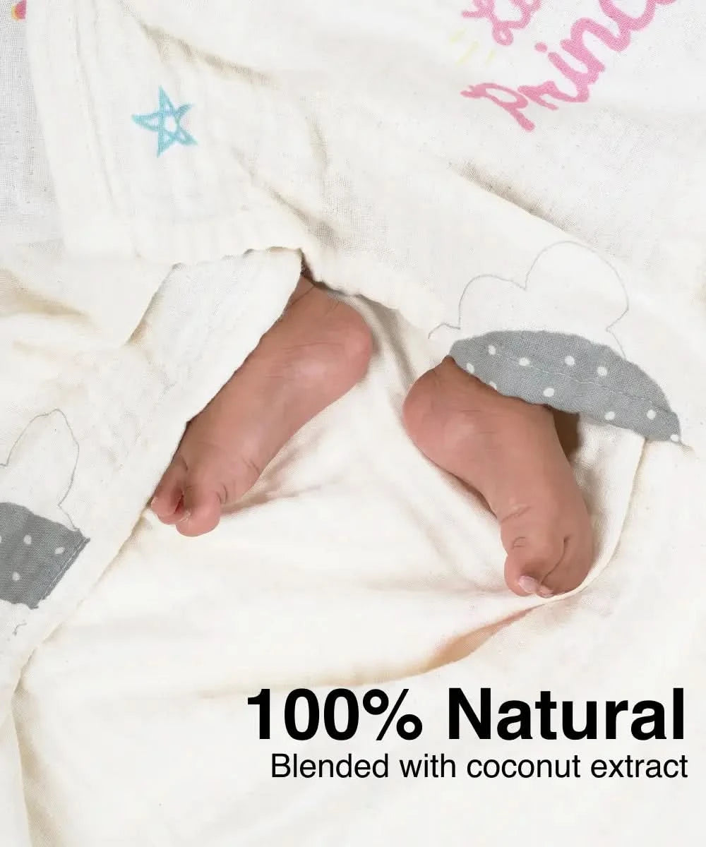 Baby's feet in a soft, textured blanket with '100% Natural' text and coconut extract mention.