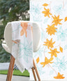 Sunlit bloom patterned towel draped over a chair with a close-up of the floral design in the corner.