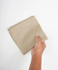 Hand holding afrozen dew hand kerchief square against a white background