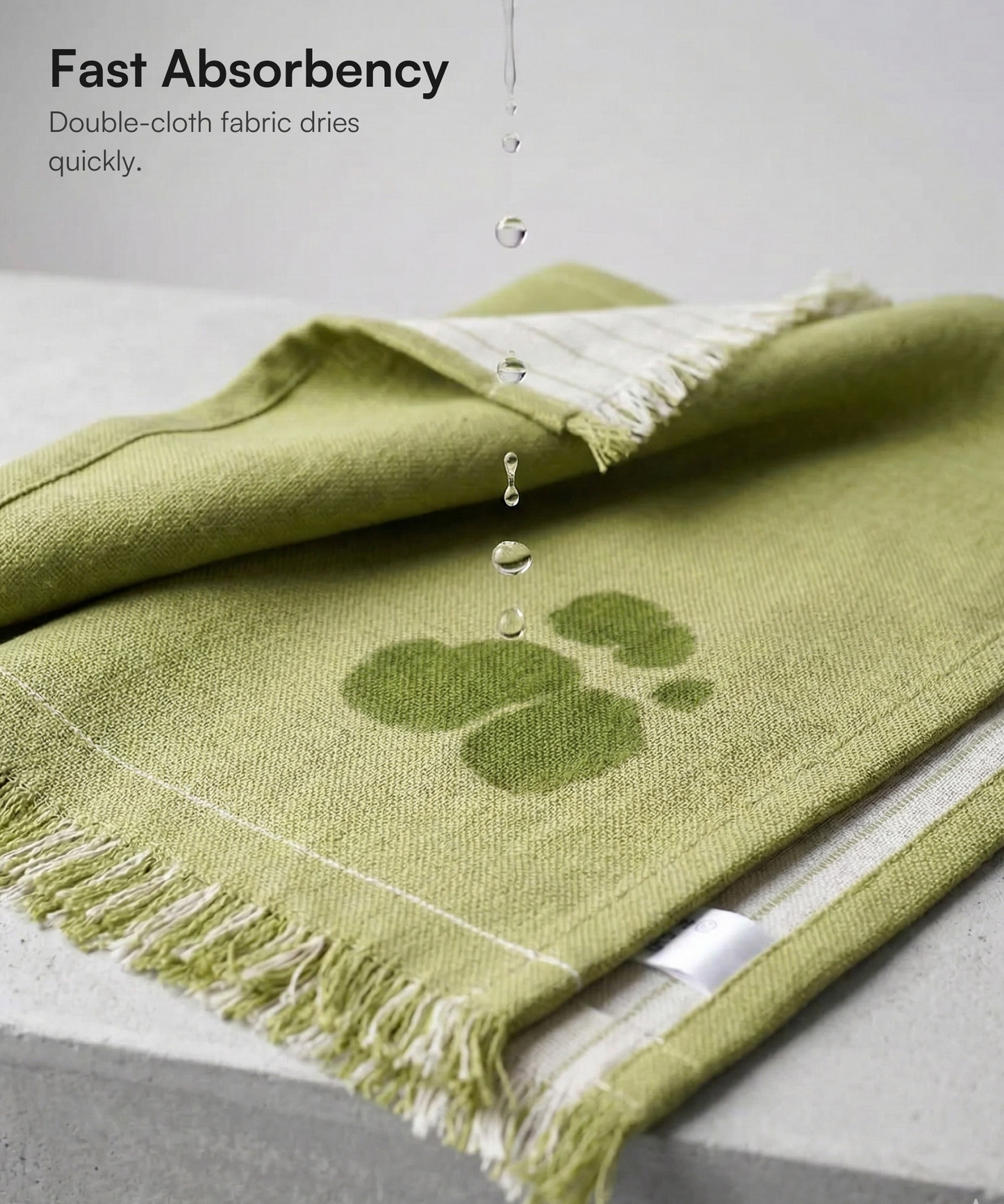 Water droplets falling onto a green Doctor Towels face towel demonstrating high absorbency.