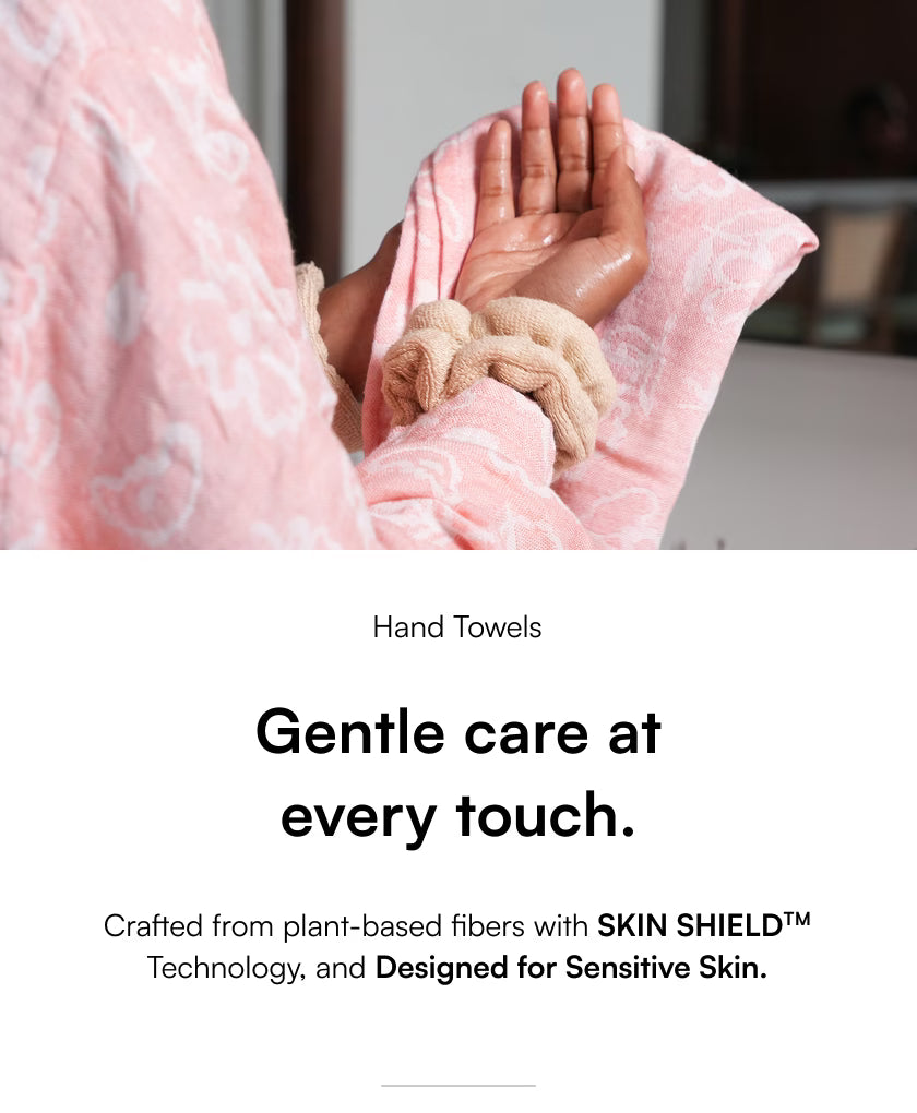 Person holding a pink hand towel with text about gentle care and skin shield technology.