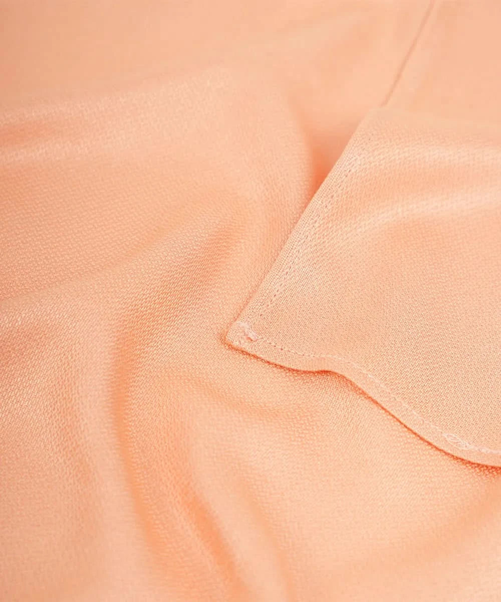 Close-up of peach-colored fabric with a subtle texture