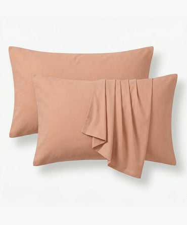 Two peach-colored pillows on a white background