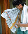 Person holding a just stripes in front of a wooden door.