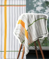 Just stripes bamboo bath towel, draped over a chair outdoors.