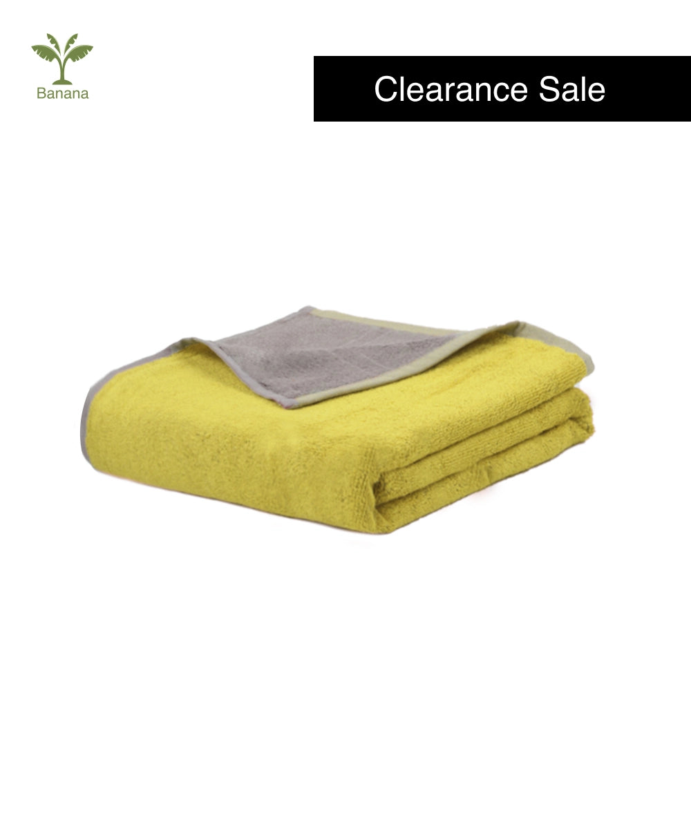 Folded yellow towel with gray lining on a white background, featuring 'Banana' brand logo and 'Clearance Sale' text.