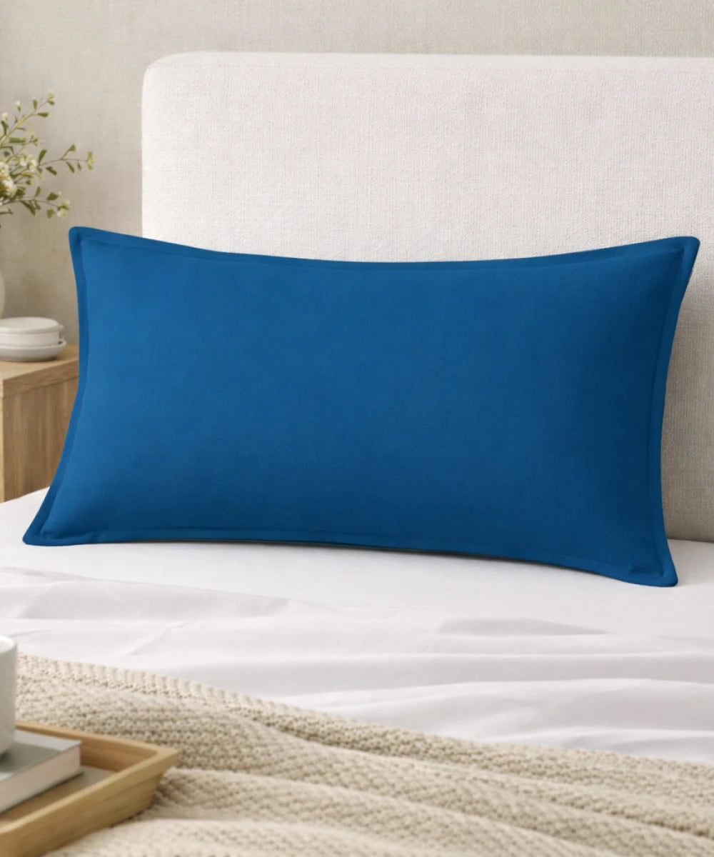 Mirage blue pillow on a bed with a neutral headboard and decor elements.