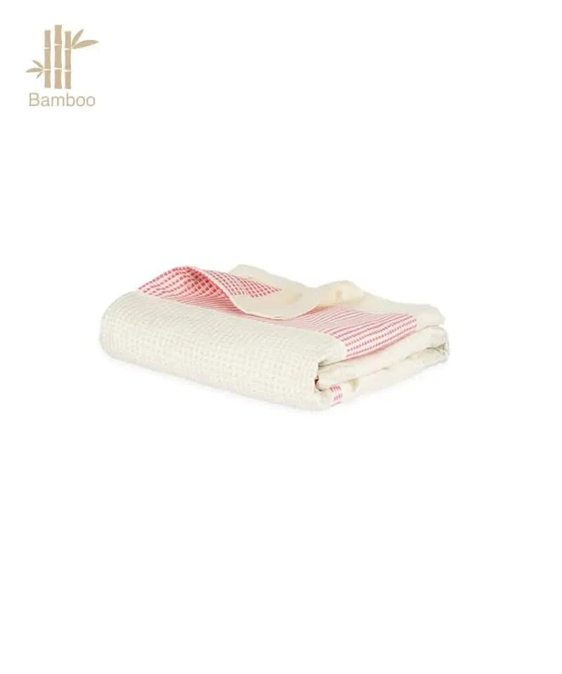 Folded towel with red patterns on a white background.