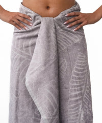 Oslo grey patterned towel draped over a person on a white background