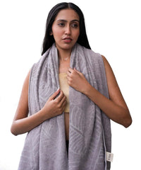 Woman wearing a oslo grey patterned towel draped over her shoulders on a white background