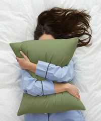 Person lying on a bed with a aloe green pillow - House of Doctor 