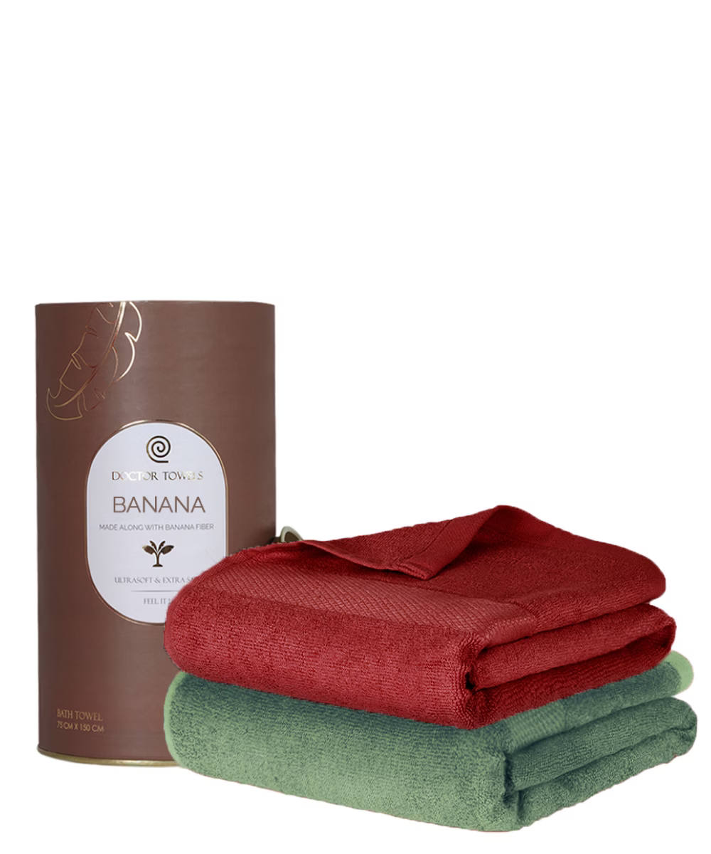 Red and green folded towels with a brown cylindrical container labeled 'Banana' on a white background