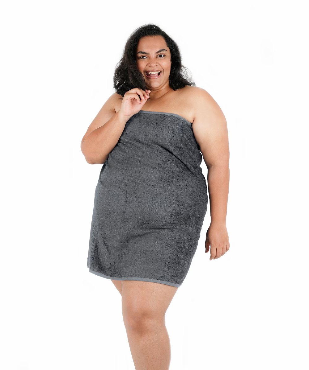 Woman wearing a grey strapless dress on a white background