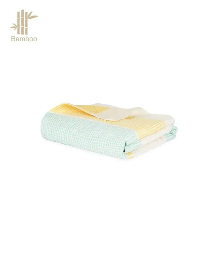 Folded bamboo towel with green and yellow pattern on a white background