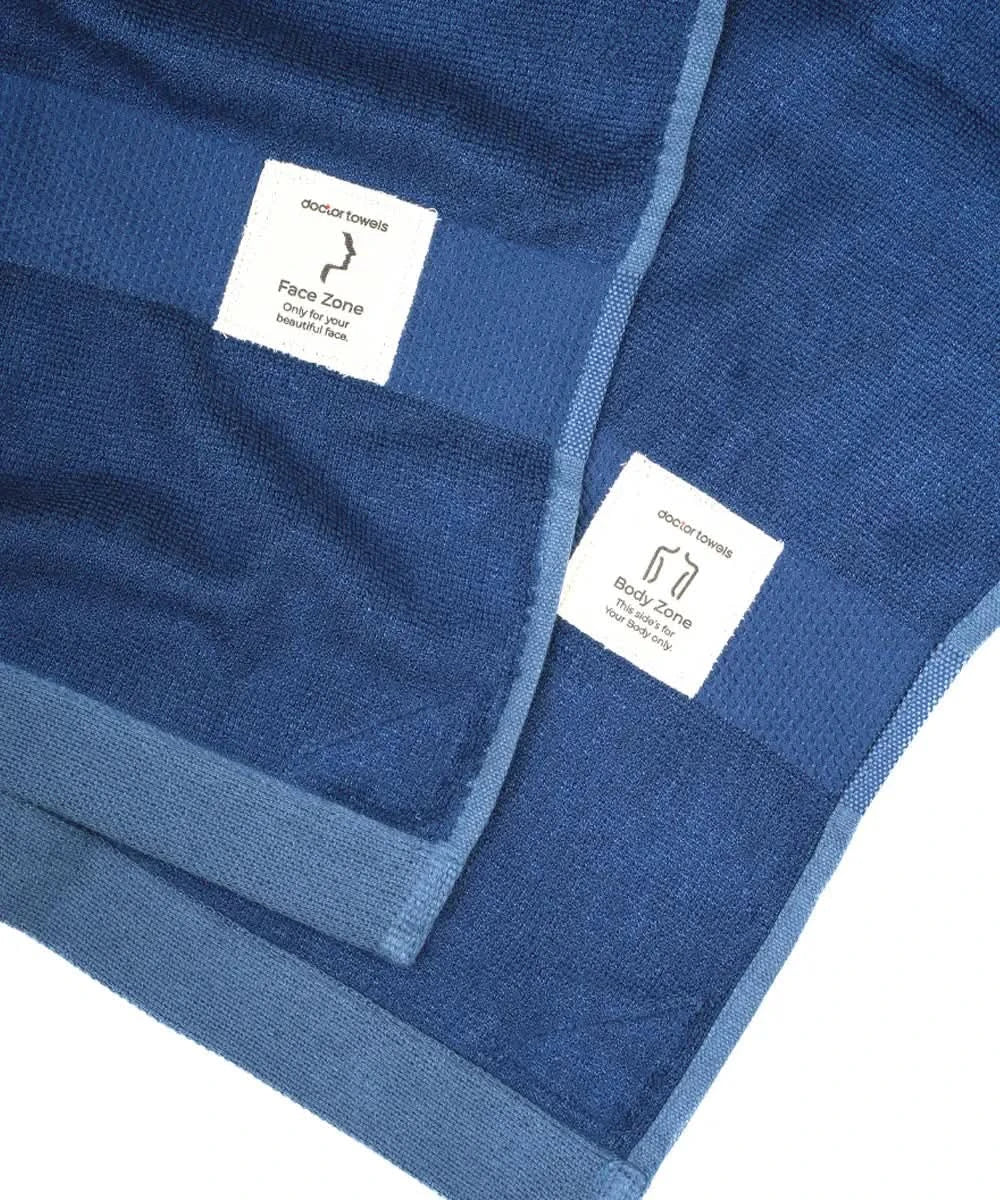 Blue towel with brand labels on a white background.