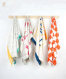 Four thirsty towels hanging on a wooden rod against a white background