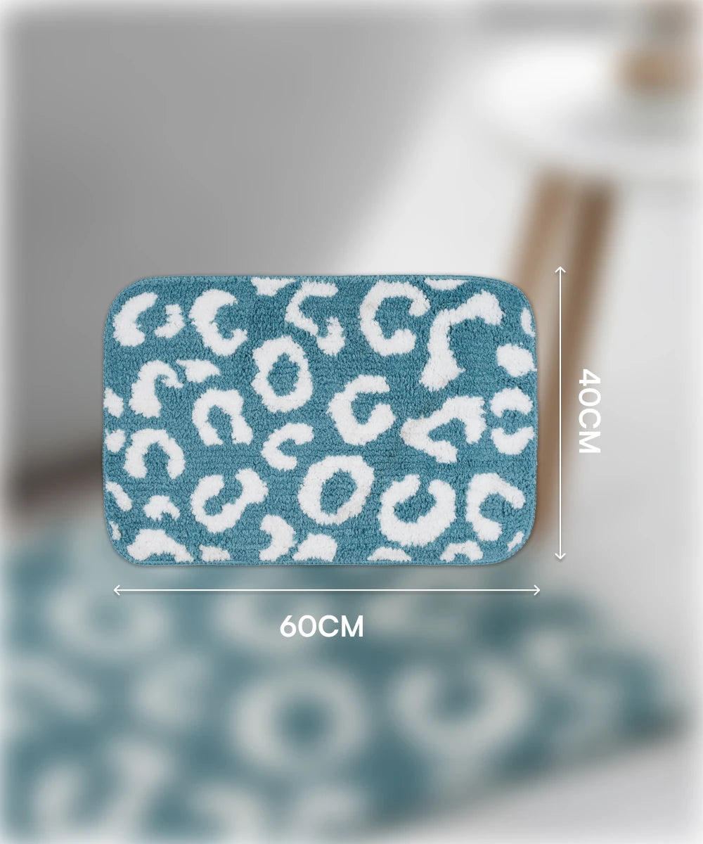 Blue bath mat with white leopard print pattern and measurements on a blurred background