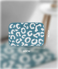 Blue bath mat with white leopard print pattern and measurements on a blurred background