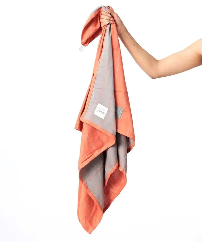 Rustic orange towel held by a hand on a white background.