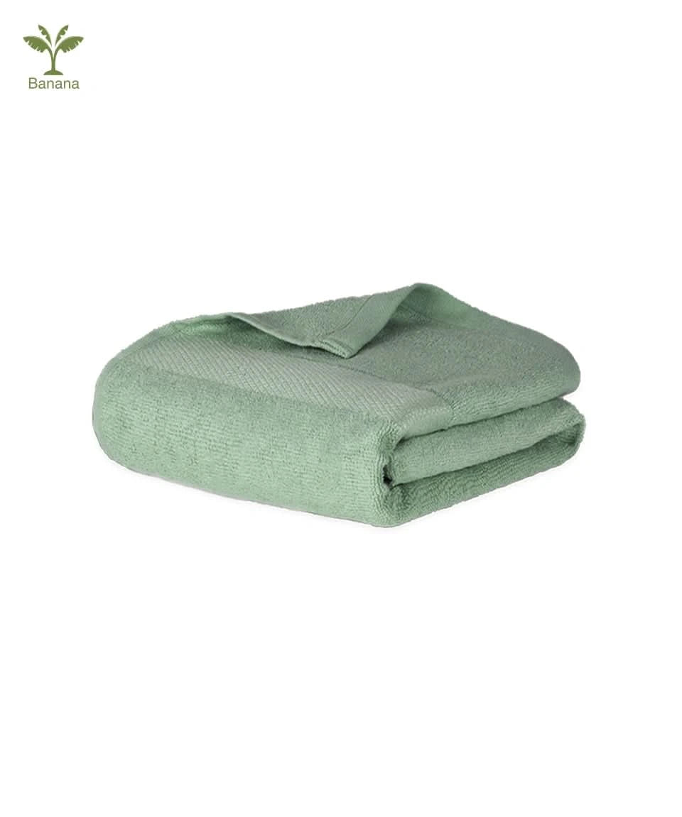 Folded green banana super light terry towel on a white background.