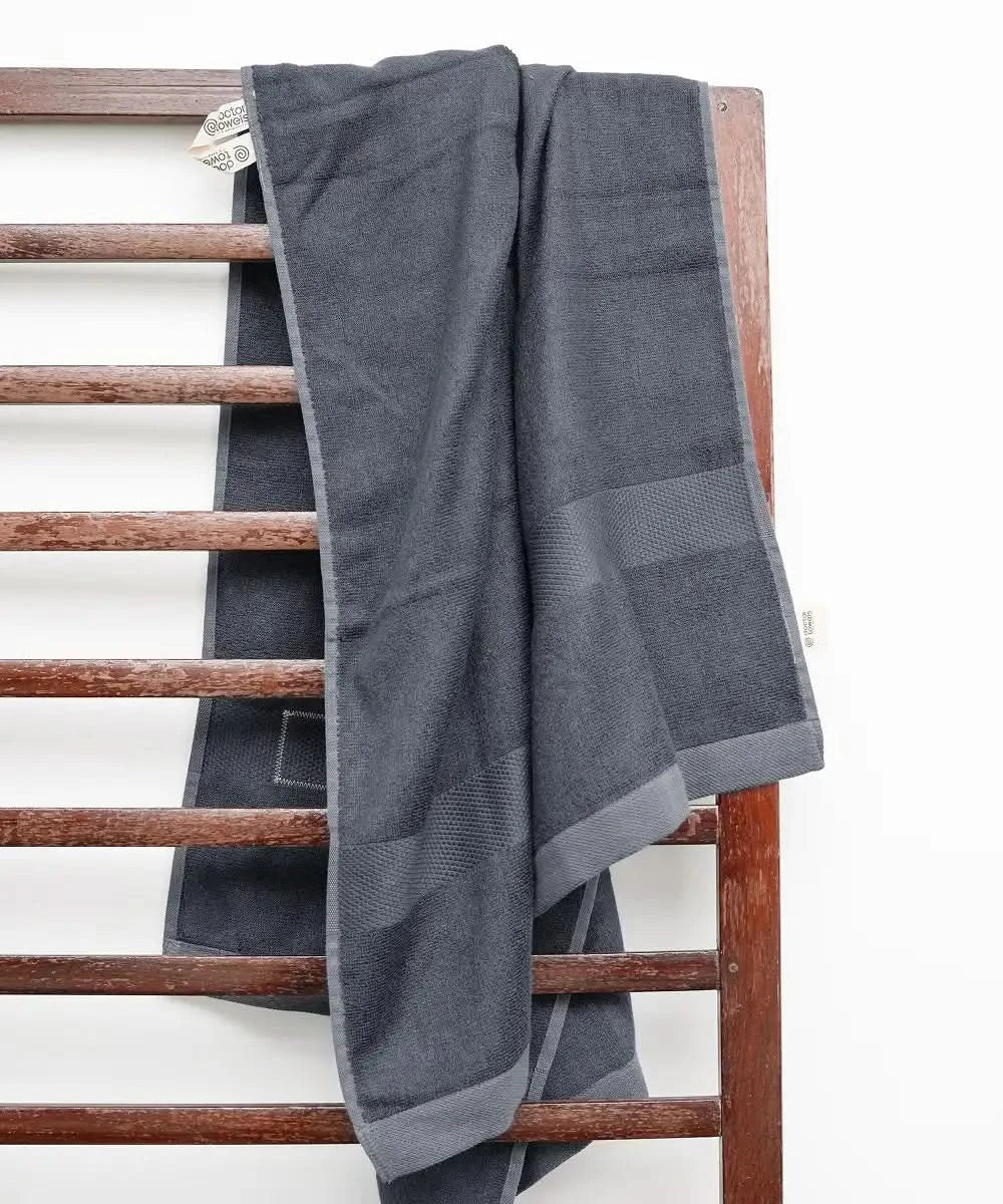 Gray towel draped over a wooden towel rack against a white background