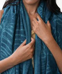 Person holding a blue patterned towel around their neck