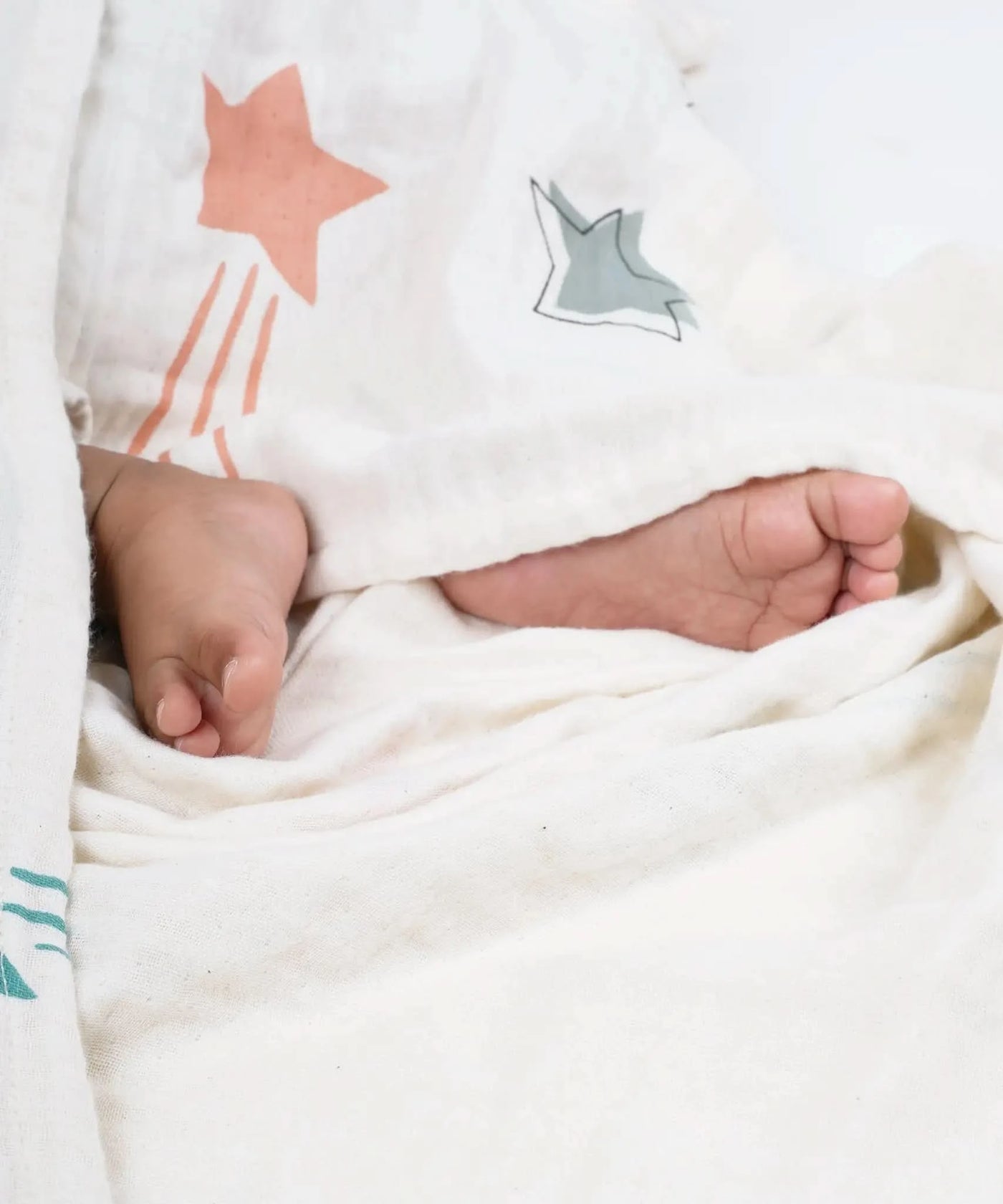 Close-up of a baby's feet wrapped in a swaddle with star patterns.