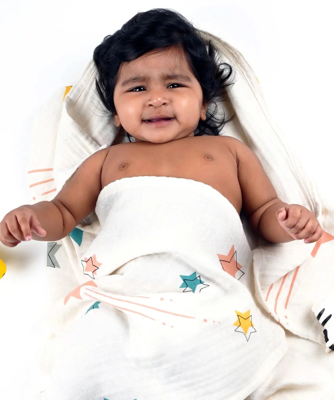 Baby wrapped in a Bamboo baby swaddle with star patterns on a white background