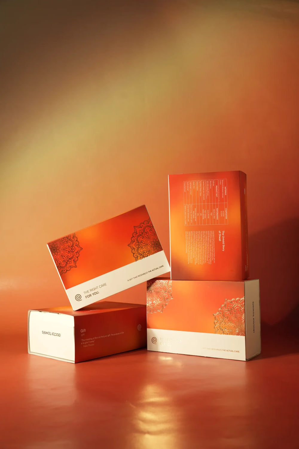 Four orange Doctor Towels gift boxes in warm light